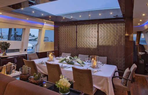 formal dining in main salon with retractable sky light above on board superyacht ‘My Toy’