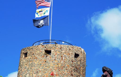 Pirate's castle in Charlotte Amalie town with three flags on a top (St.Thomas, U.S.Virgin Islands)