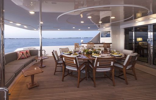 Al fresco dining set-up on luxury yacht AMITIE with sofa seating and bar area