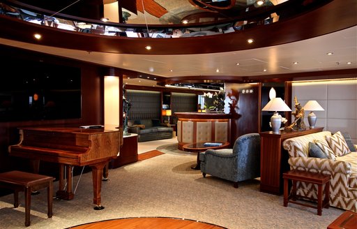 grand piano and seating areas in main salon of charter yacht ‘Lauren L’ 