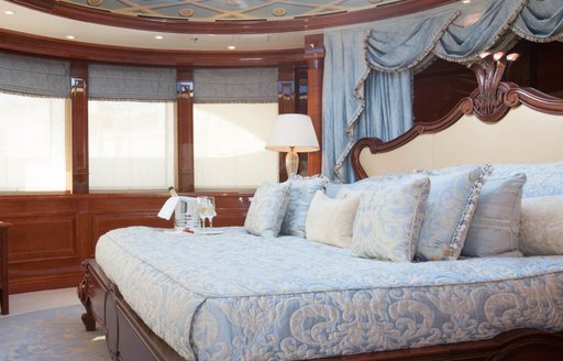 benetti superyacht st david master suite with bed with blue detailing and palatial headboard