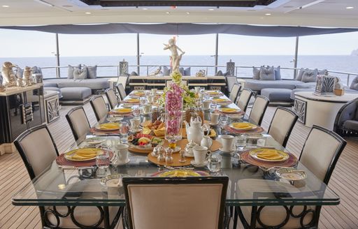 Overview of a formal alfresco dining table on the aft deck of charter yacht Silver Angel