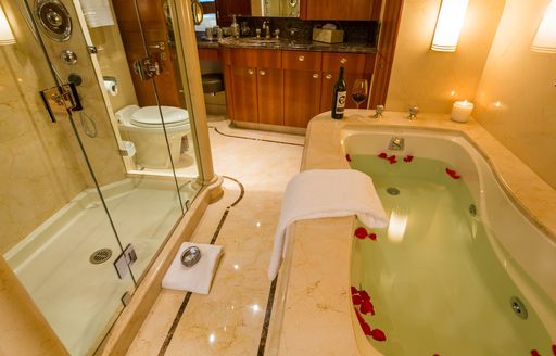 master en suite with bath and glass of red on board charter yacht 'Chasing Daylight'