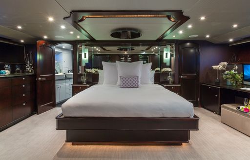 sophisticated master suite with rich wood furniture aboard luxury yacht UNBRIDLED 