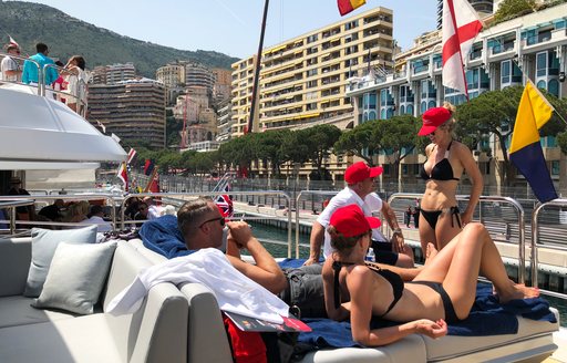 spectators sunbathe on board a superyacht while watching the Monaco Grand Prix