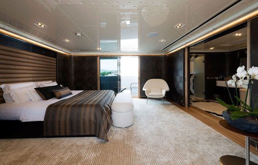 Master cabin onboard charter yacht AQUARIUS, central berth facing starboard with a fold down balcony in the background