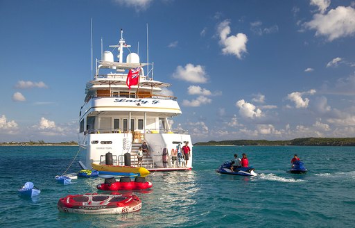 Aft decks of luxury charter yacht Lady J, with toys and tenders out on the water