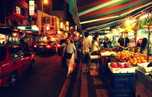 A woman walks past a traditional food market in Malaysia
