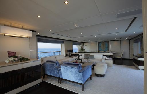 The neutral tones and modern furnishings inside the main salon of superyacht SKYLER