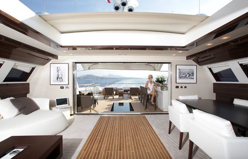 Open plan interior of superyacht GEMS II, with open roof and light colored seating