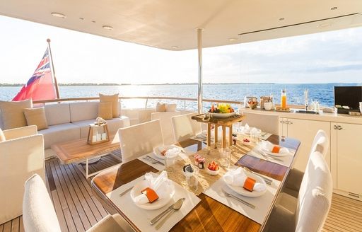 alfresco dining table and lounge on upper deck aft of charter yacht PIONEER 