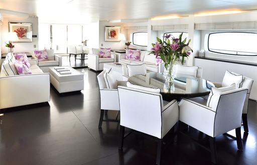 dining table and lounge area in the main salon of superyacht Infinity Pacific