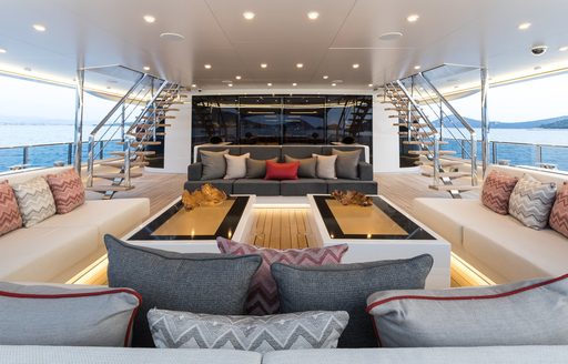 Aft deck social area, with tables and sofas on board luxury yacht SAMURAI