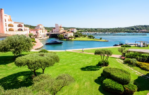 A wide view east of the Hotel Cala di Volpe lawn, marina and guest buildings on a sunny day in Costa Smeralda, Sardinia, Italy 
