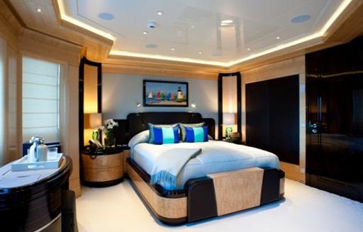 Guest cabin on superyacht Arience showing bed with picture above