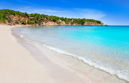 Turquoise sea lapping sandy beach in the Balearic islands