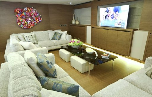 upper deck lounge with tv and butterfly mural on super yacht OURANOS