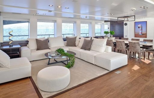 Main salon onboard charter yacht AFRICA I, lounge area in the foreground with dining aft