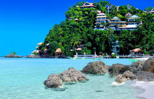 Houses nestled into rock and jungle on an island in the Philippines in Southeast Asia