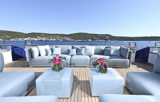 multitude of sky blue sofas make up the main aft deck on board charter yacht IPANEMAS 