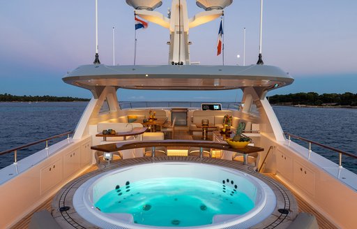 Deck Jacuzzi onboard charter yacht MANA I, with alfresco dining option in the background
