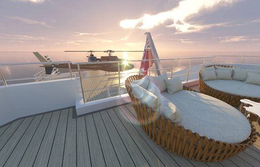 Helipad onboard charter yacht LA DATCHA at sunset, with wicker seating in the foreground