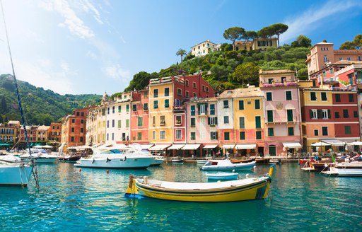 colourful houses overlooking a small italian harbour with boats 