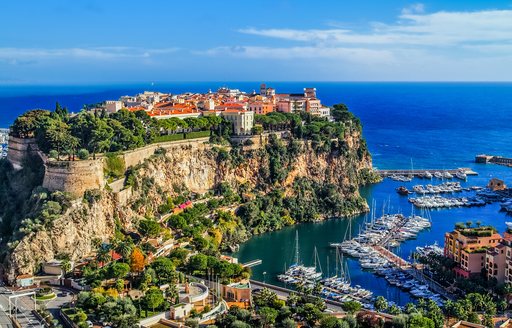 Principality of Monaco perched on a rock precipice in the French Riviera, with yachts in the Port Hercules marina below