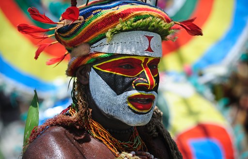 Papua New Guinea tribesman with painted face and colourful headress