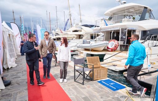 Visitors at the East Med Multihull & Yacht Charter Show in discussion adjacent to displaying luxury yacht charters
