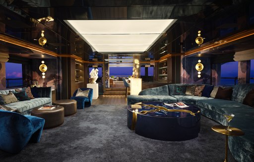 Overview of the main salon onboard charter yacht GALAXY, rich color scheme with seating to port and starboard 
