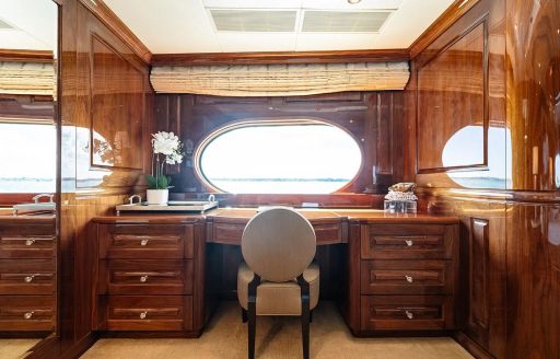 Private study area with a desk under an oval window onboard superyacht charter REMEMBER WHEN