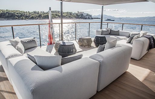 Aft deck onboard charter yacht SEVERIN'S, exterior lounge area with plush seating accompanied with views of the sea