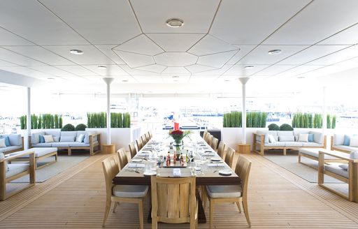 long dining table with cosy lounging options on main aft deck of superyacht ‘Indian Empress’ 