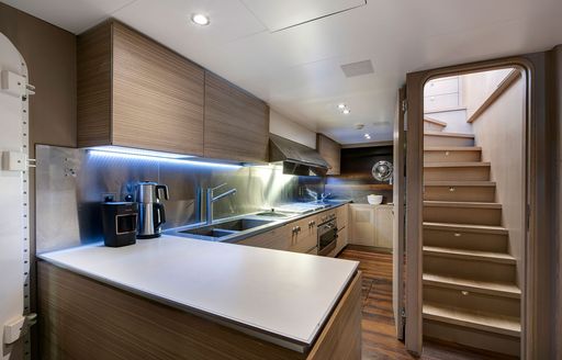 Galley onboard charter yacht ATLANTIKA with staircase leading to main deck