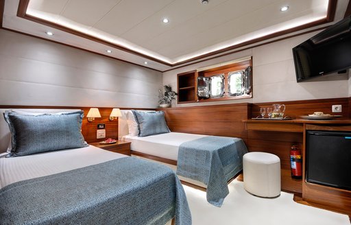 Twin guest cabin onboard sailing yacht charter ALESSANDRO I, twin single beds with a night stand and a small hull window