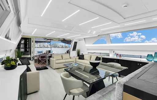 Overview of the main salon onboard charter yacht GYPSEA, dining area in foreground with lounge area in the background