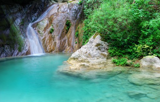 A waterfall into a turquoise lagoon in Tahiti