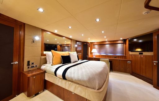 Master cabin onboard charter yacht CATALANA, central berth facing starboard with wall mounted TV opposite.