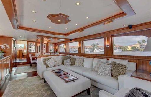 Overview of the main salon onboard charter yacht LEXINGTON, with plush lounge area forward and interior dining in the background