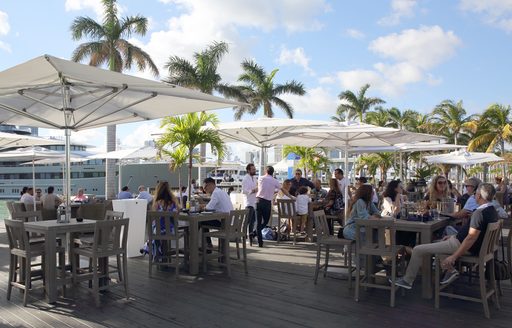 visitors at the Miami Yacht Show 2019 enjoy food and drink in lounge area