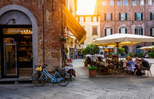Italian town with bicycle on wall and restaurant 
