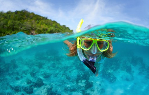a lady snorkelling in the azure waters of Thailand