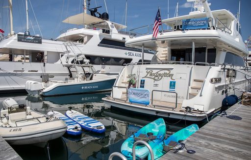 Aft view of motor yacht charters berthed at Safe Harbor Newport Shipyard, with water toys adjacent in the water