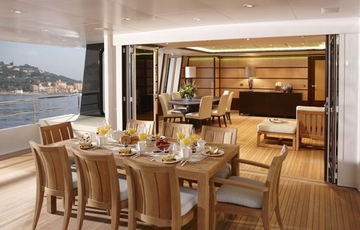 al fresco dining table on upper deck aft of luxury yacht GLADIATOR with skylounge beyond