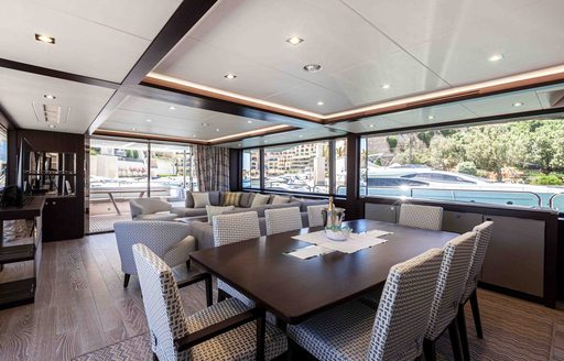 Dining area onboard charter yacht NEW EDGE, large dining table with eight seats surrounded by large windows