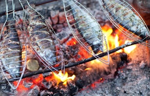 Traditional style of grilling the fish over a fire in Corsica