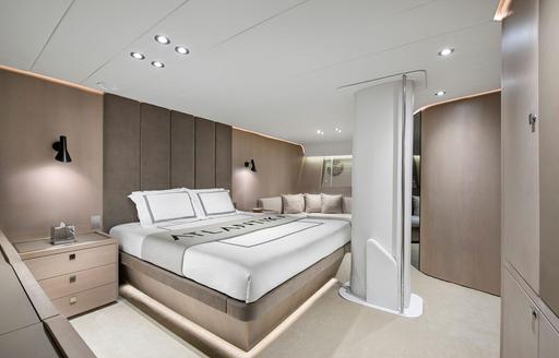 Master cabin onboard charter yacht ATLANTIKA, central berth facing forward with seating area in the background