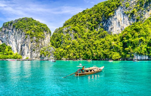 Longtail boat on water in cove in Thailand
