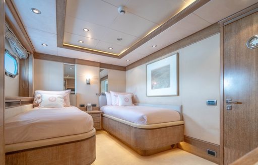 A twin cabin onboard charter yacht ARTEMISEA, twin berths with small hull window to port
